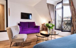 a living room with a purple couch and a table at Plaza Tour Eiffel in Paris