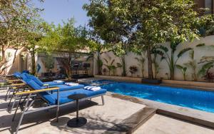 a swimming pool with blue lounge chairs next to a building at Special offer at 22 by spacey #54 Studio in Maadi in Cairo +13 photos