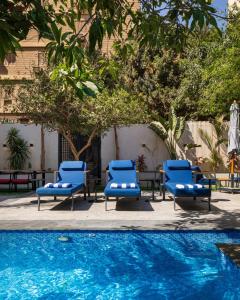 a group of blue lounge chairs next to a pool at Special offer at 22 by spacey #54 Studio in Maadi in Cairo