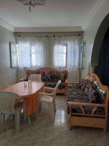 a living room with a table and a couch at Dar Al Yasmine in Tabarka