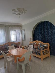 a living room with a table and a couch at Dar Al Yasmine in Tabarka