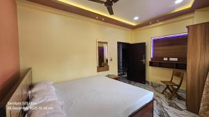 a bedroom with a bed and a chair and a window at Akshay Guest House in Krishnanagar