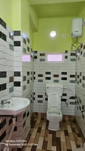 a bathroom with a toilet and a sink at Akshay Guest House in Krishnanagar +26 photos