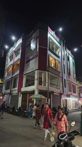 a group of people walking in front of a building at Akshay Guest House in Krishnanagar