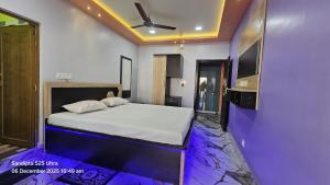 a bedroom with a bed and a ceiling fan at Akshay Guest House in Krishnanagar