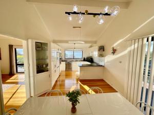 a kitchen and dining room with a table and chairs at 3BR Retreat with Sunset Views over Brisbane Water in Green Point