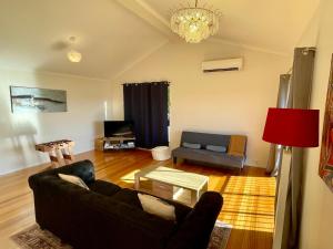 a living room with a couch and a table at 3BR Retreat with Sunset Views over Brisbane Water in Green Point