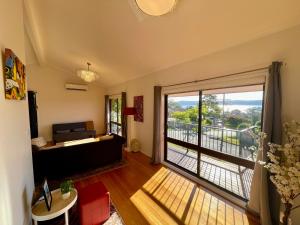 a living room with a couch and a large window at 3BR Retreat with Sunset Views over Brisbane Water in Green Point