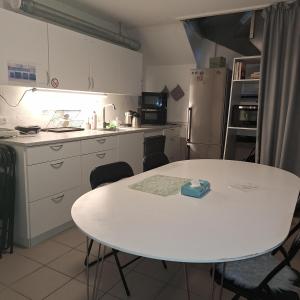 a kitchen with a white table and a white refrigerator at Craizy Hans in Odense +17 photos
