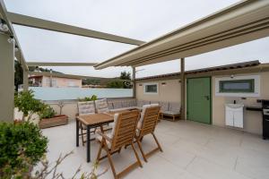 a patio with a table and chairs and a green door at Asini deluxe suite 4, with rooftop terrace and breathtaking views in Asíni