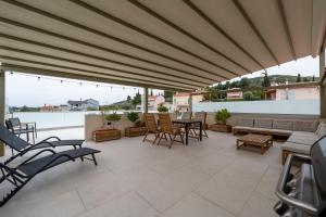 a patio with a couch and chairs and a table at Asini deluxe suite 4, with rooftop terrace and breathtaking views in Asíni
