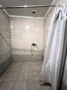 a bathroom with a shower with a shower curtain at Sayak hotel & hostel in Karakol +69 photos