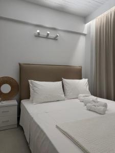 a bedroom with a bed with white sheets and pillows at PJ Properties Sunset Residence Sounio in Sounio