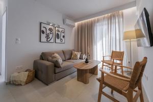 a living room with a couch and a table at PJ Properties Sunset Residence Sounio in Sounio