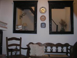 Habitación con 2 espejos, silla y sofá en Casa Rural y Restaurante Casa Adriano, en Alanís