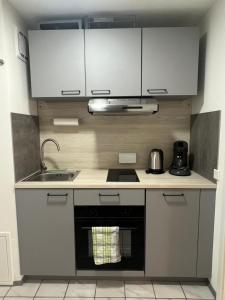 a small kitchen with white cabinets and a sink at Apartment Sebald in Ingolstadt +15 photos