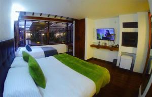a hotel room with two beds and a window at Hotel Casona Usaquen in Bogotá
