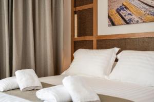 a bedroom with two beds with white sheets and pillows at Elysian Beachfront Luxury Suite with Jacuzzi - Sea & City View - ADULTS ONLY in Kos