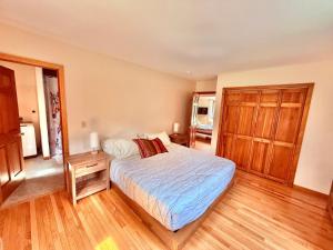 a bedroom with a bed and a wooden floor at The Suite at Liberty Woods in Belchertown