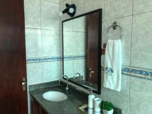 a bathroom with a sink and a mirror at Upwind in Araruama