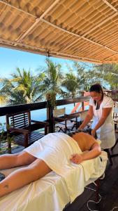 a woman is making a woman laying on a bed at Upwind in Araruama