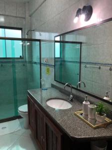 a bathroom with a sink and a toilet and a mirror at Upwind in Araruama