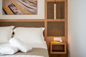 a bedroom with a bed with white pillows on it at Elysian Beachfront Luxury Suite with Jacuzzi - Sea & City View - ADULTS ONLY in Kos +48 photos
