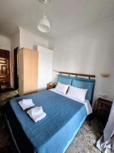a bedroom with a blue bed with two towels on it at Anna Garden Sidari in Sidari