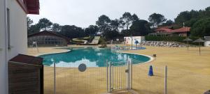 a swimming pool with a fence around it at l' échappée belle in Mimizan-Plage