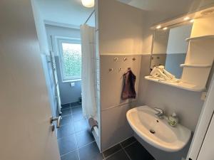 a small bathroom with a sink and a toilet at Steilsand 1 - 200 M Zum Strand in Cuxhaven +69 photos