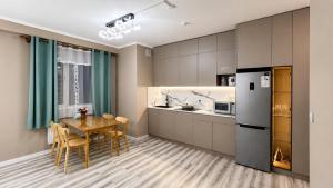 a kitchen and dining room with a table and a refrigerator at Stylish Cozy Apartment in UB in Ulaanbaatar