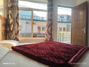 a bedroom with a bed with a large window at Kunjapuri Homestay in Uttarkāshi +18 photos