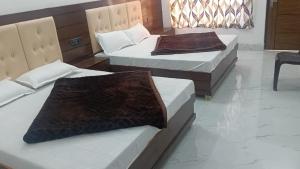 two beds in a hotel room withskirts at Kunjapuri Homestay in Uttarkāshi