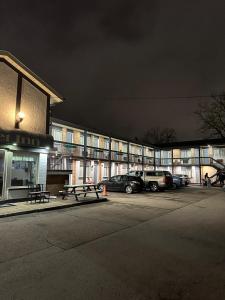 a parking lot in front of a building at night at Sunset Inn in Niagara Falls