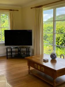 a living room with a flat screen tv and a coffee table at Riverview Retreat in Perth