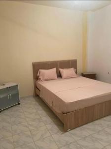 a bedroom with a bed with pink pillows on it at Dar Al Yasmine in Tabarka