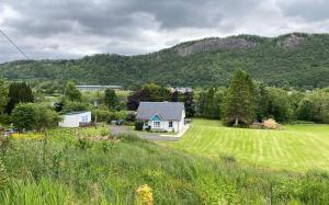 a house in a field with mountains in the background at Riverview Retreat in Perth