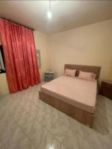 a bedroom with a bed with a red curtain at Dar Al Yasmine in Tabarka +3 photos
