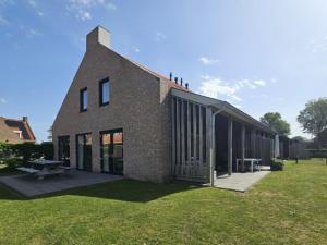 a brick building with a picnic table in the grass at De Plevieren in Buren