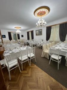 a banquet room with white tables and white chairs at Hotel Villa DavidL in Sagarejo