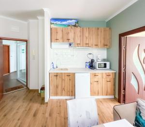 a kitchen with wooden cabinets and a counter top at Sunny Cozy Apartment Primorsko in Primorsko