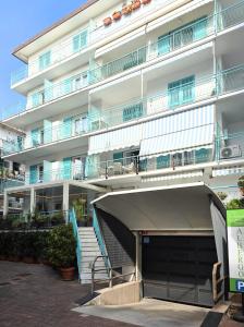 a large white building with stairs in front of it at Albergo Giuan Arma di Taggia in Arma di Taggia