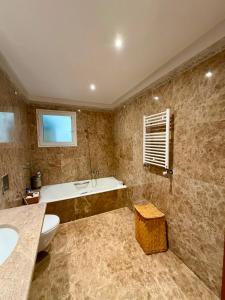 a bathroom with a tub and a toilet and a sink at Comfy 2Bdrs Marsa in Carthage +13 photos