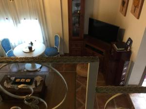 sala de estar con mesa y TV en La Posada de Menchu en Sanlúcar de Barrameda