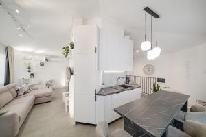 a kitchen and living room with white walls and a table at Sanseveria in Španjola