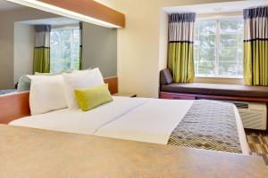 Cette chambre comprend un grand lit et un canapé. dans l'établissement Microtel Inn & Suites by Wyndham Daphne, à Daphne