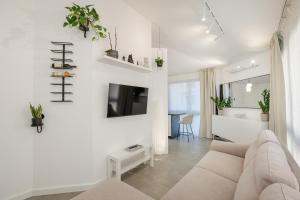 a white living room with a couch and a tv at Sanseveria in Španjola