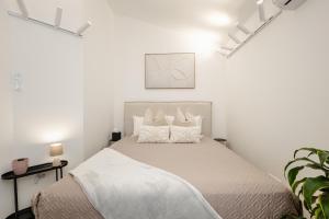 a white bedroom with a bed with white sheets and pillows at Sanseveria in Španjola
