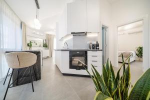 a kitchen with white cabinets and a bar with a chair at Sanseveria in Španjola +32 photos