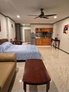a bedroom with a bed and a couch and a table at New world condo1104 in Ban Chak Phai